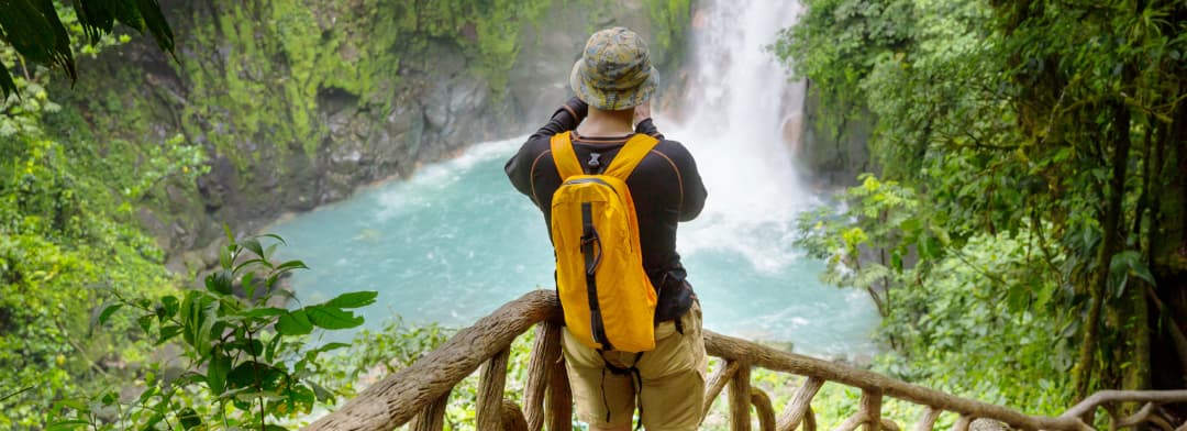 Excursionista frente a una cascada en la selva